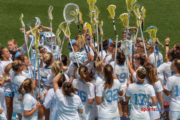 UNC Women's Lacrosse team celebrates before the championship game with their lacrosse sticks raised as they cheer © Equity IX - SportsOgram - Leigh Ernst Friestedt