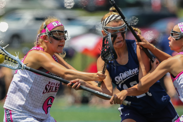 Skywalkers girls lacrosse player fires a shot against two Jersey select lacrosse players wearing pink headbands at Nike Elite Girls Lacrosse early recruiting tournament © Equity IX - SportsOgram - Leigh Ernst Friestedt